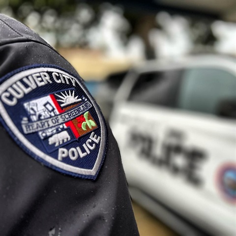 culver city police department officer shoulder patch with patrol vehicle in the background